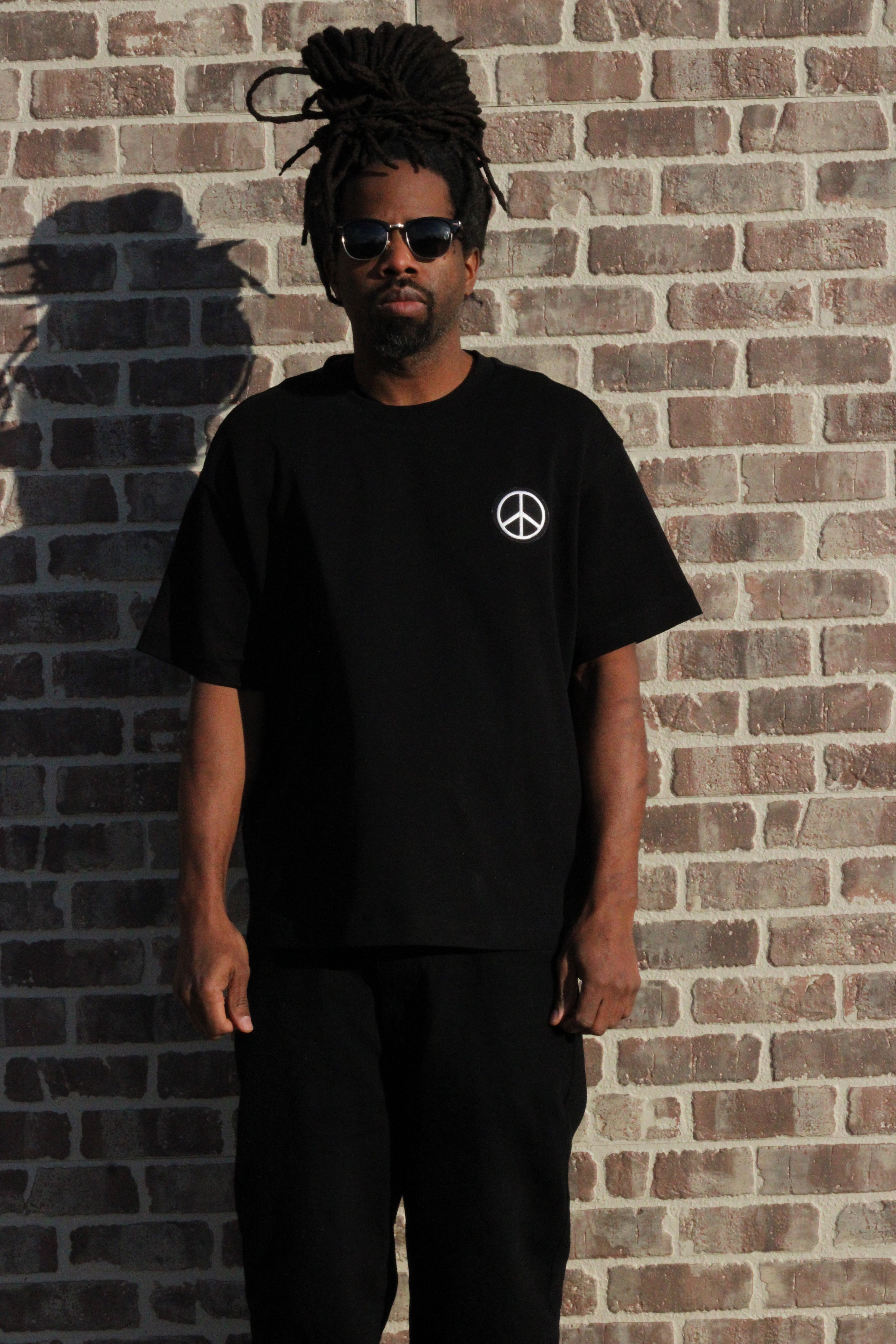 Model wearing black peace sign graphic tee online store
